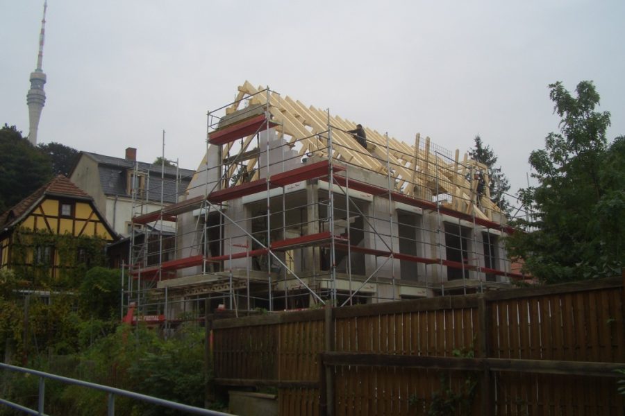 Neubau mit Fernsehturm im Hintergrund.