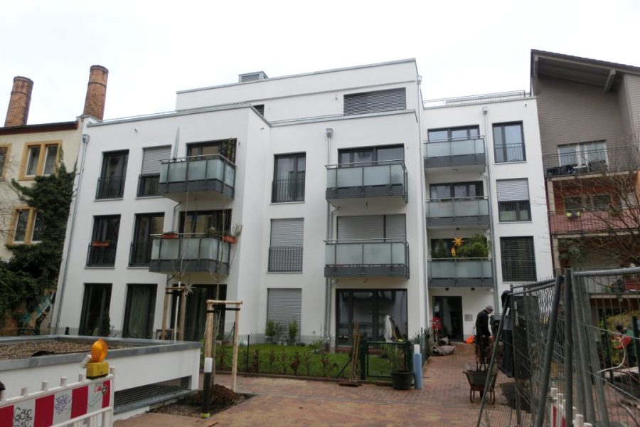 fertiges Mehrfamilienhaus mit Balkonen.