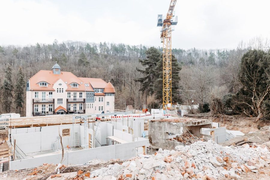 Außenansicht eines restaurierten Gebäudes vor einer weiteren Baustelle.